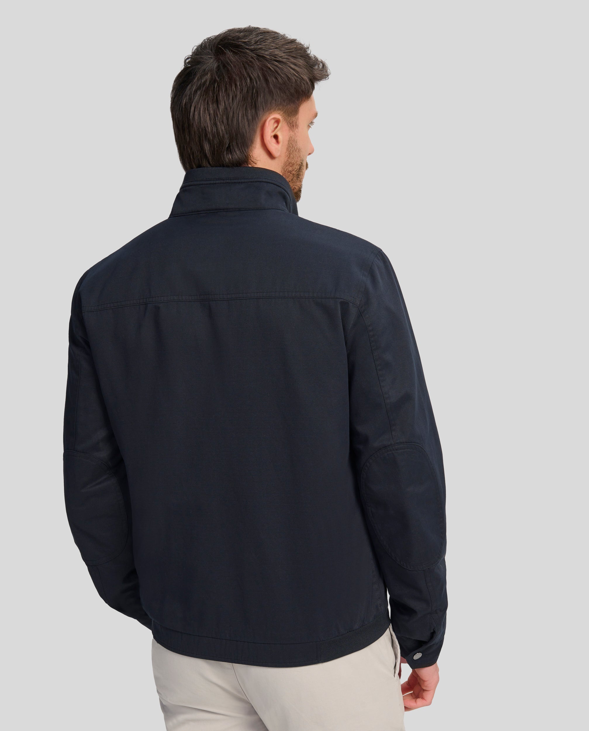 Buccino | JULIO | MARINO | foto de espalda |Cazadora en tejido algodón con coderas, lleva una tira de punto fino en cintura y cuello.  Forrada liso a contraste.  Dos bolsillos laterales de fácil acceso con broche personalizado y dos bolsillos con cremallera en el interior. Puños ajustables con broche personalizado.  Cierre frontal con cremallera vista personalizada.