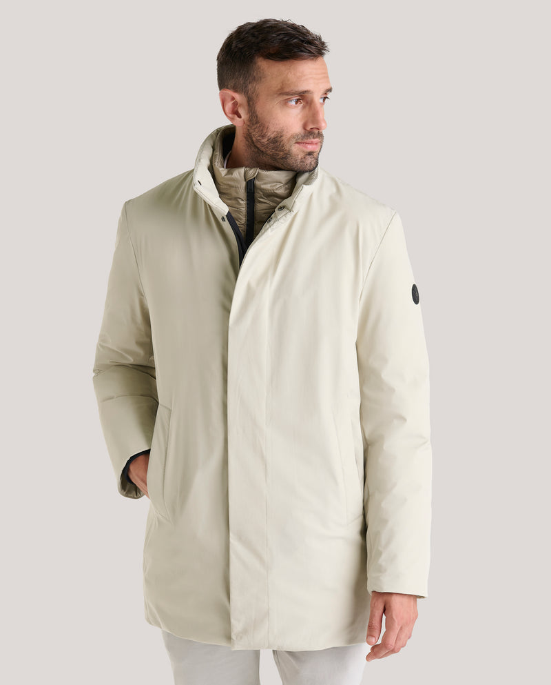 Parka lisa de largo medio en tejido liso tres capas de Cromdaltex® impermeable y transpirable con capucha oculta en el cuello con una cremallera personalizada waterproof, a efectos de chaleco lleva un pecherín desmontable en tejido técnico ligero. Dispone de abertura en el bajo espalda que cierra con broche oculto magnético y puños con punto en el interior.

Forrada en tejido técnico ligero acolchado en horizontal con relleno de boata laminada ecológica (Sorona). Dispone de dos bolsillos laterales de fácil 